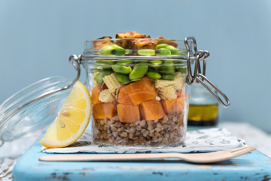 Buckwheat and sweet potato salad with cornflakes, edamame and crispy tofu in a glass jar