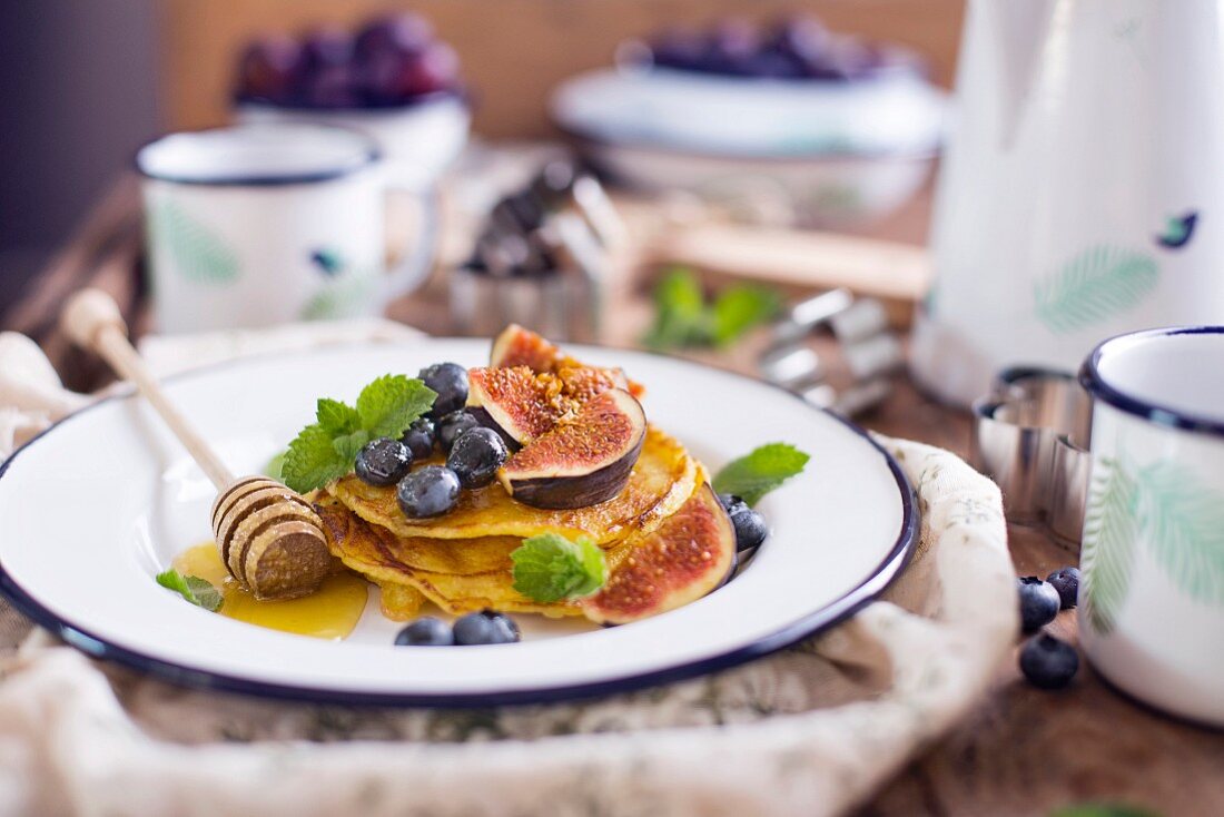Gluten Free Pancakes With Figs And Blueberries with Mint on a white plate