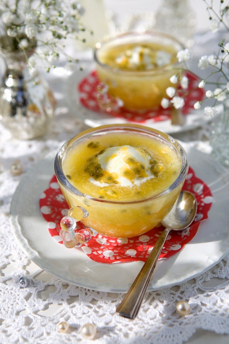 Cold passion fruit bowls with vanilla ice cream on a summer table outdoors