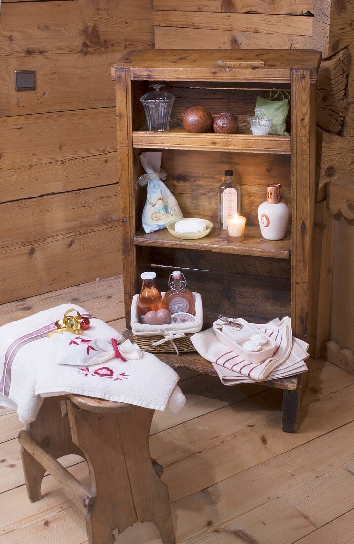 Stool in front of bath utensils on old shelves in cabin