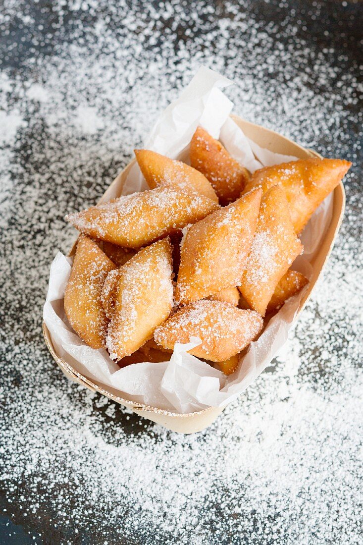 Fasnetküchle (mini cakes), with icing sugar in a basket