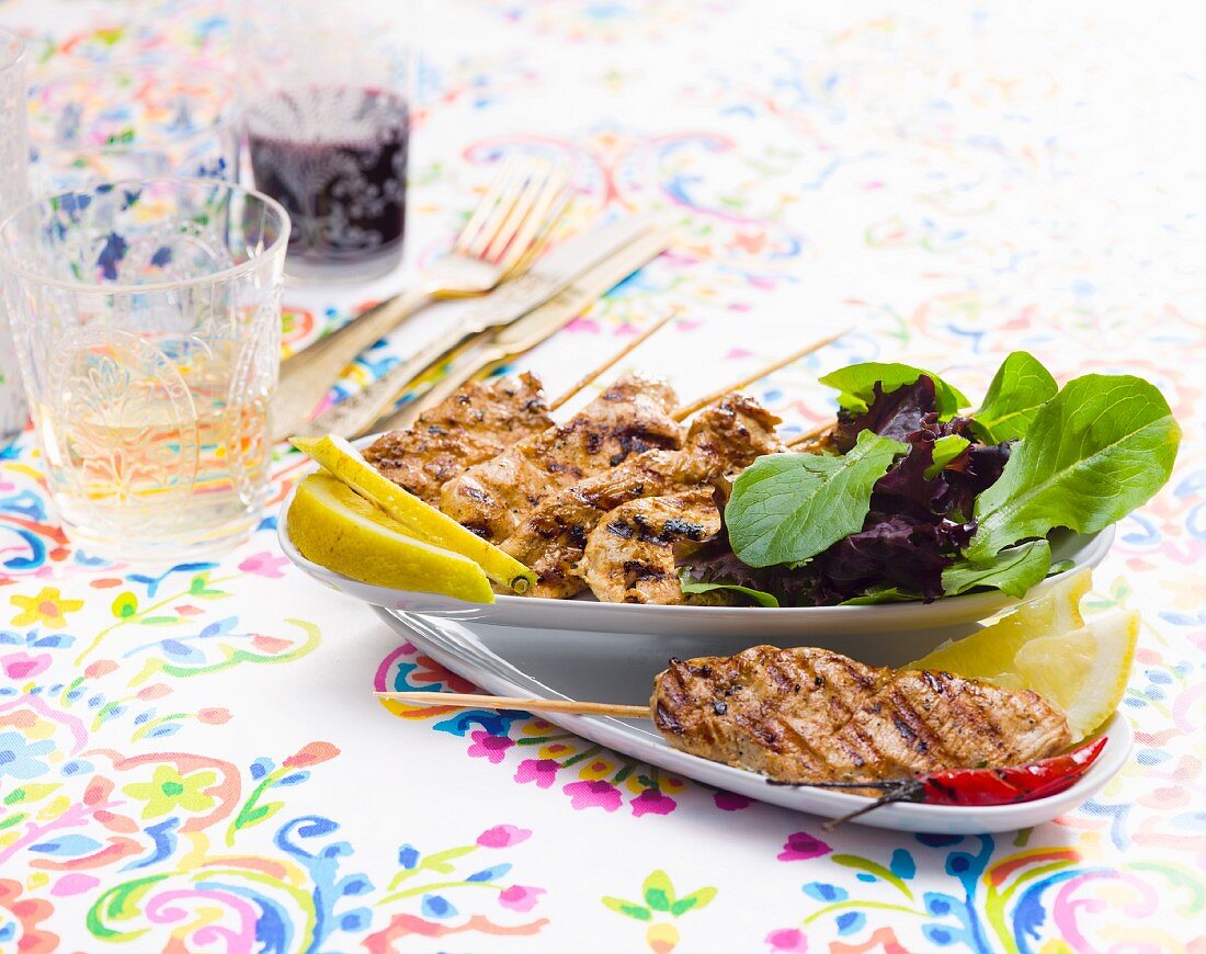 Grilled meat kebabs with a mixed leaf salad