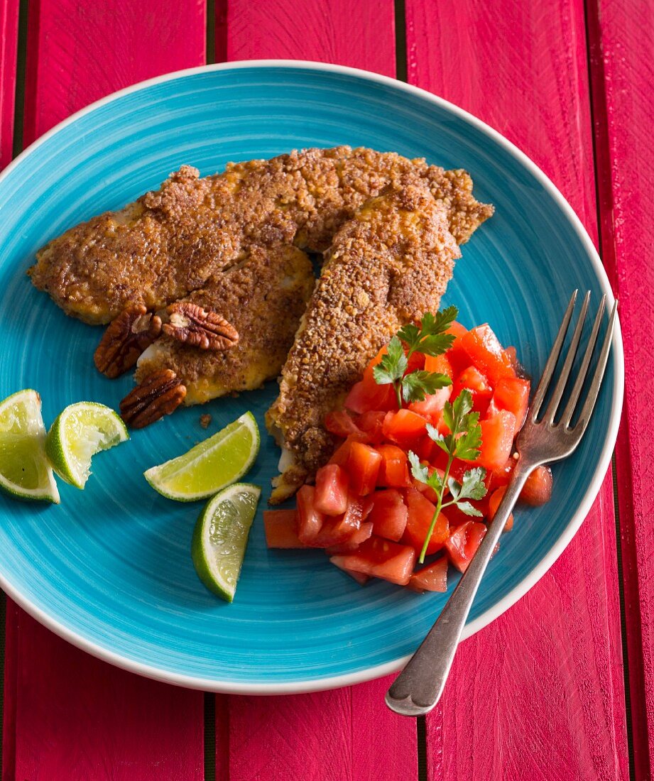 Fish fillets with a pecan crust, diced tomatoes and limes