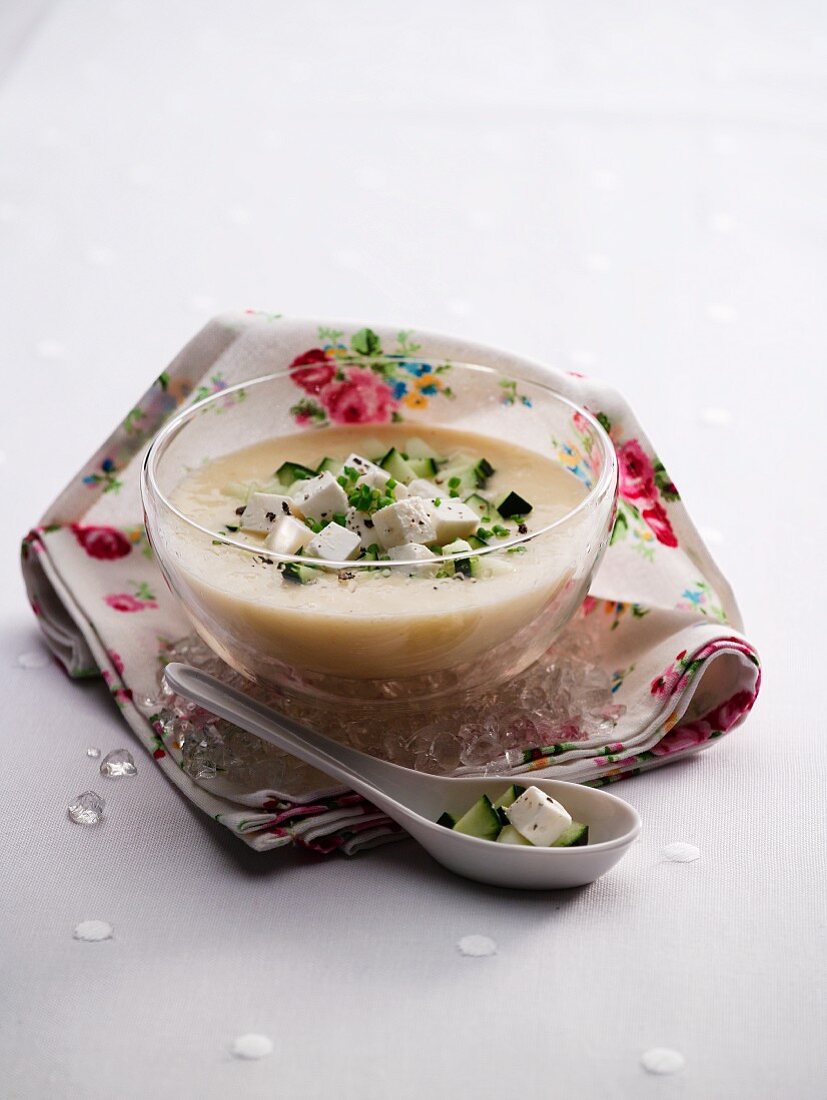 White gazpacho with feta cheese in a glass bowl