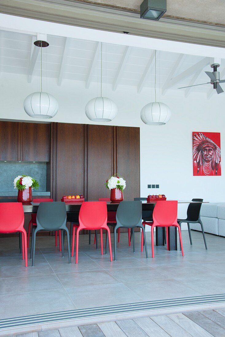 Esstisch mit schwarzen und roten Stühlen in der offenen Küche