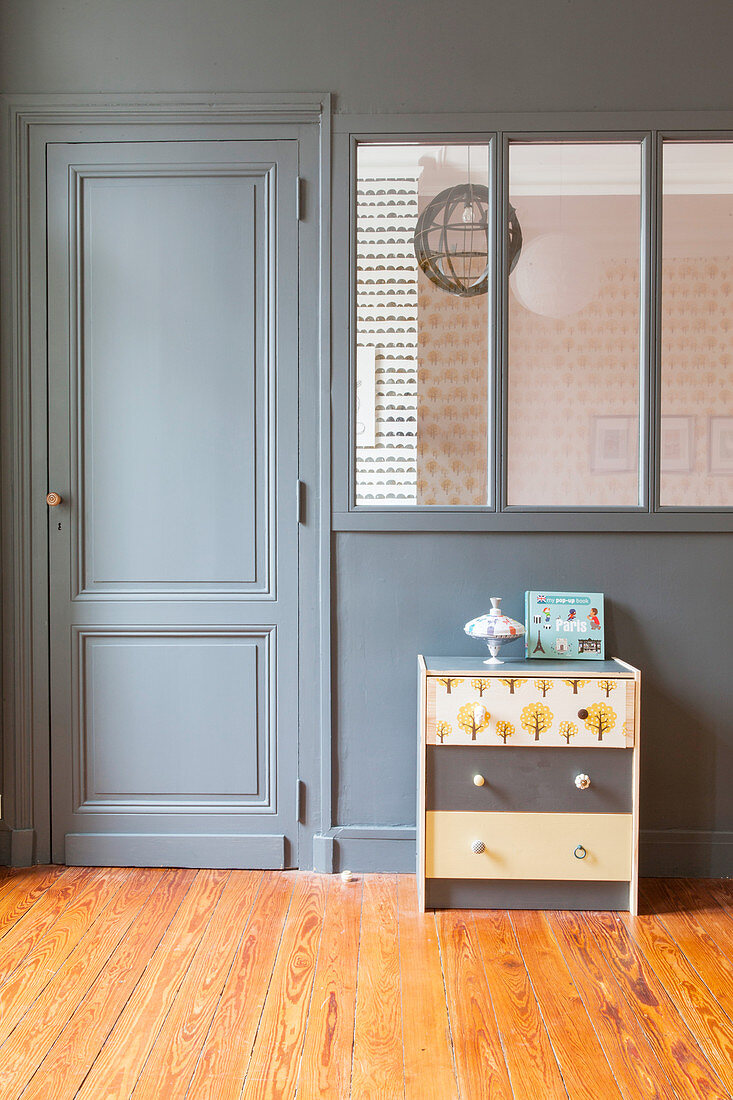 Chest of drawers in front of grey-painted partition wall
