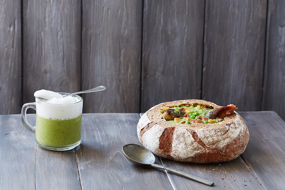 Petersilien-Cappuccino und Erbsensuppe serviert in ausgehöhltem Brot