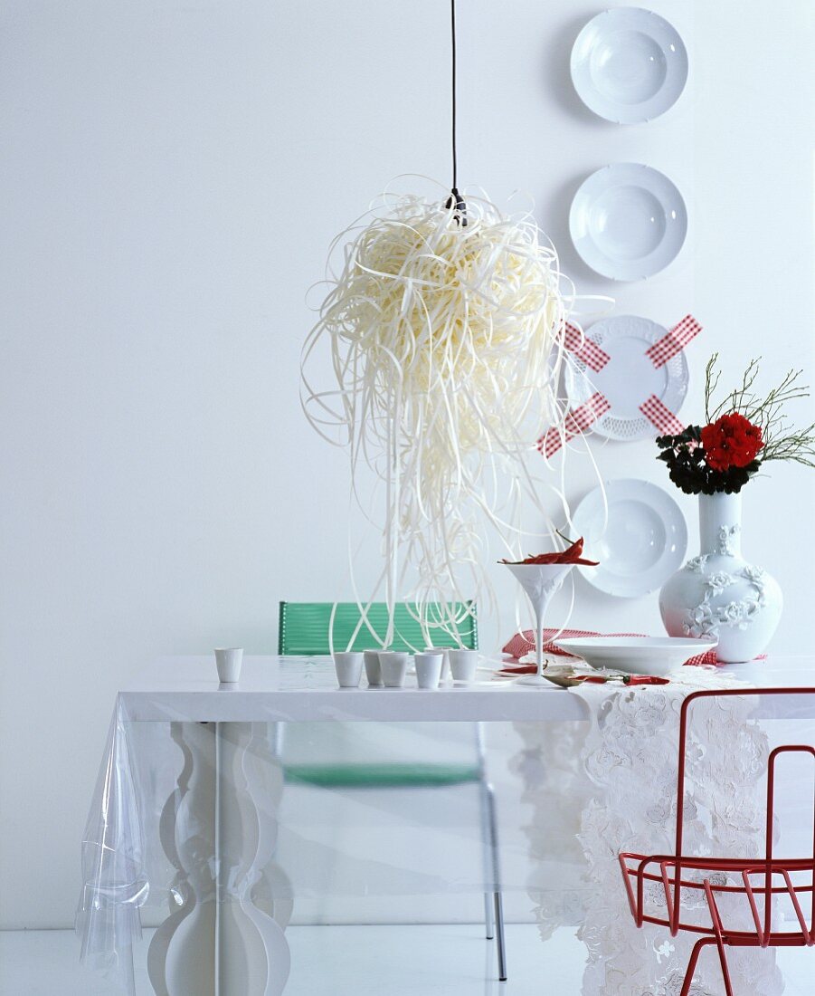 Decorative wall plates and designer lamp in white, futuristic dining room