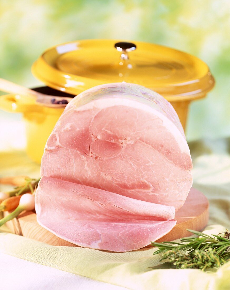 Cooked ham on a wooden chopping board