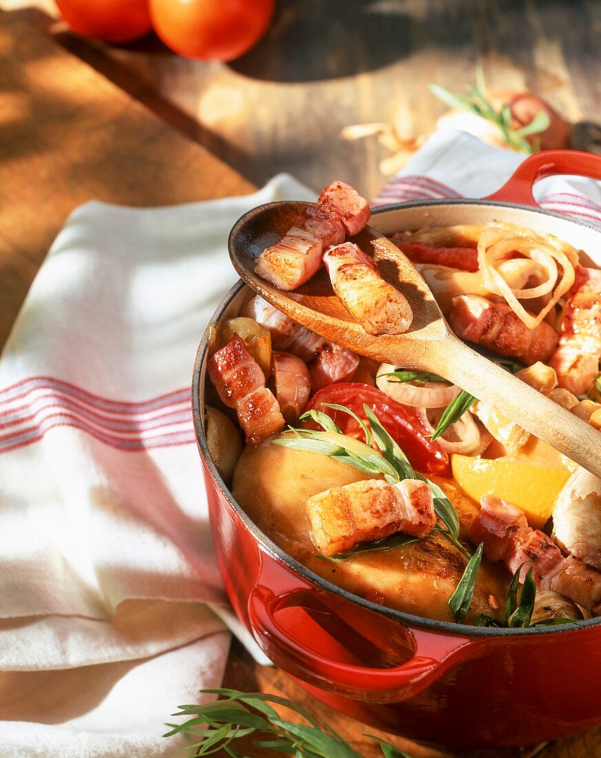 Chicken with bacon strips, tomatoes and tarragon in a casserole dish