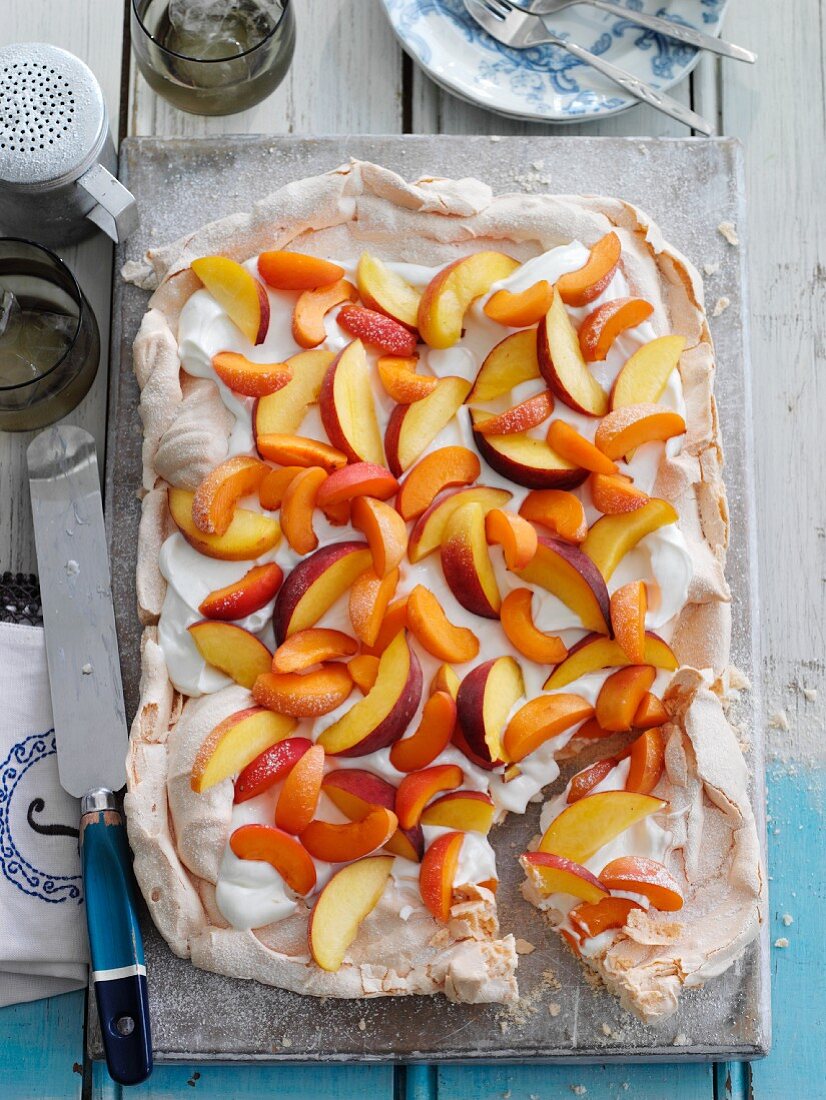A summery meringue cake with cream, apricots and peaches