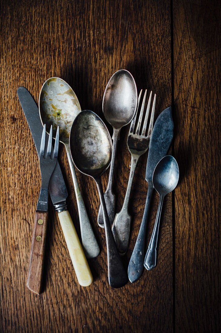 Old cutlery on a wooden background (top view)