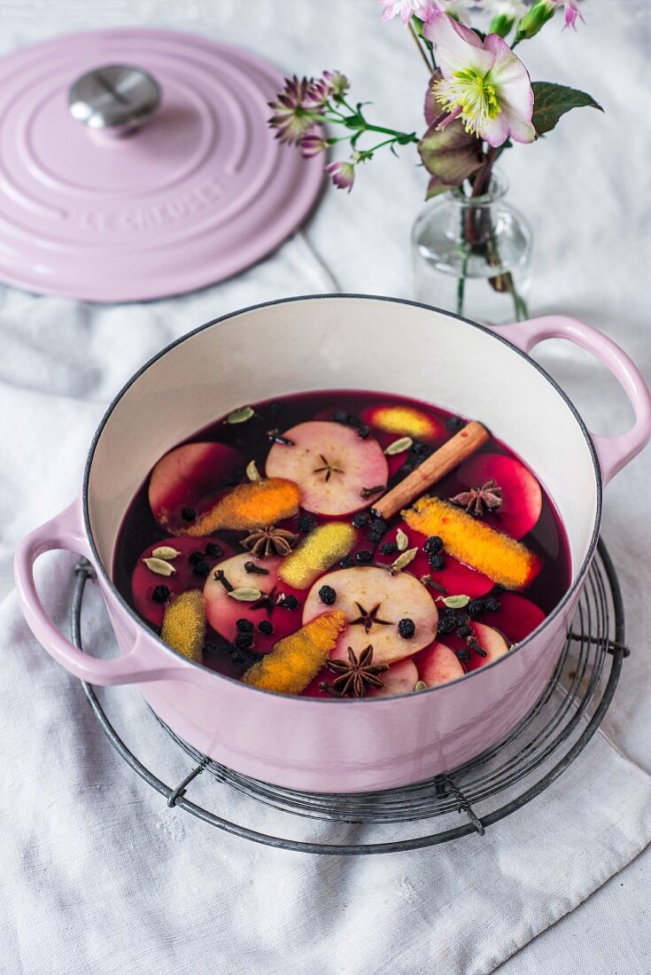 Advent punch with apple slices and spices in a cooking pot