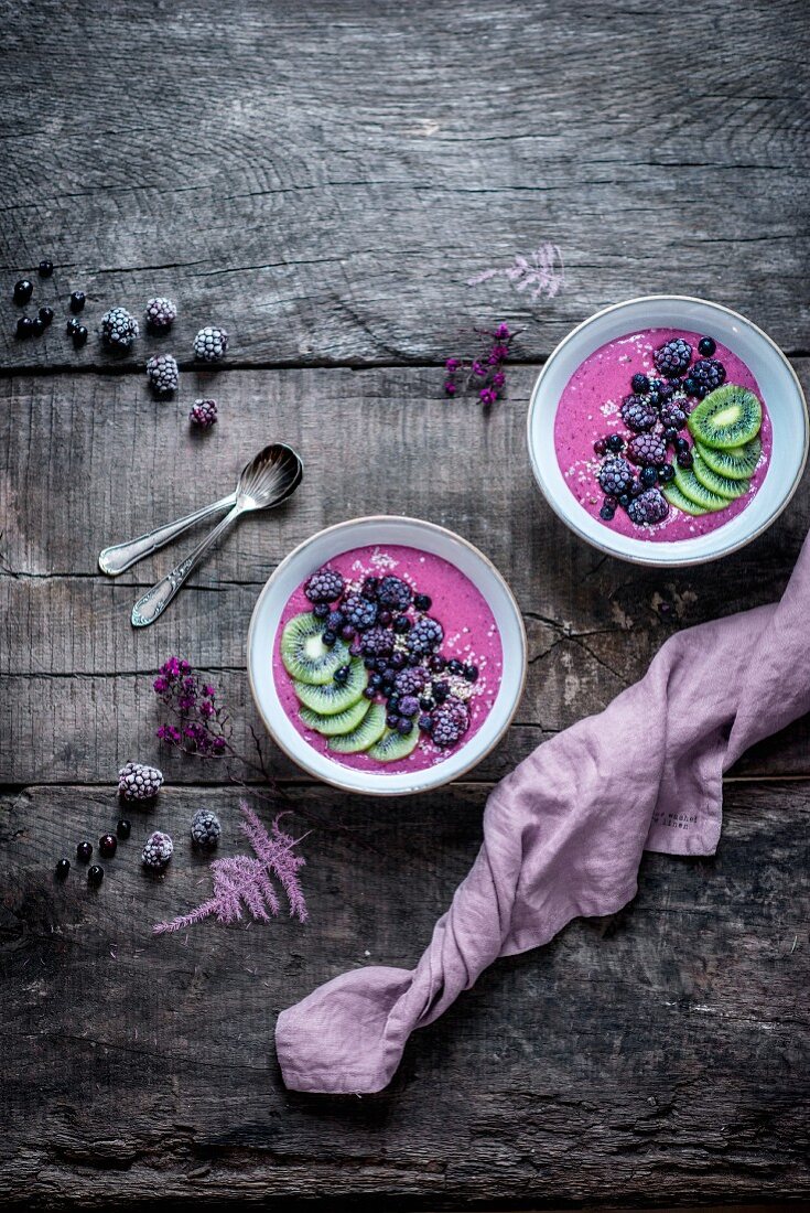 A smoothie bowl with almond milk, bananas, blackberries, blueberries, kiwi and hemp seeds