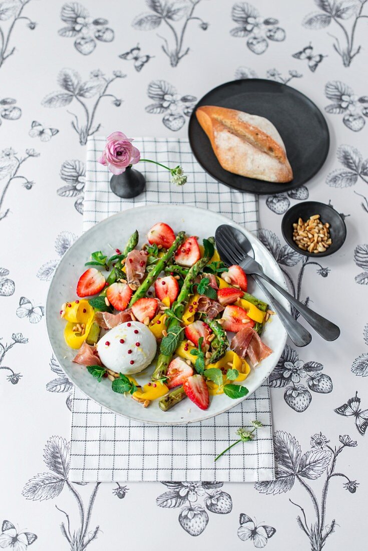 Erdbeer-Mango-Salat mit grünem Spargel, Büffelmozzarella, Parmaschinken, rosa Pfefferbeeren und Minze