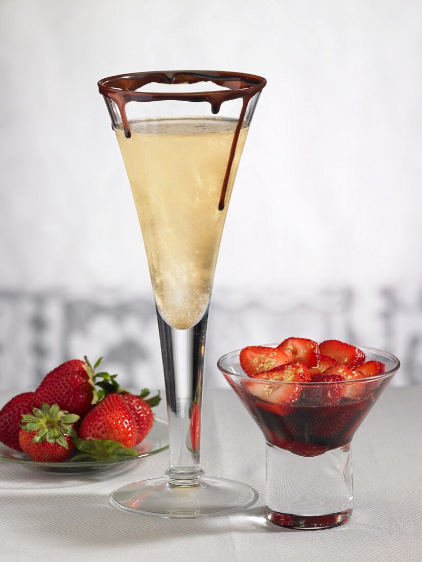 A champagne glass with chocolate and strawberries