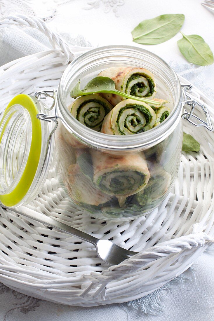 Lunch in a jar: Pancake rolls filled with spinach and cottage cheese in a glass jar