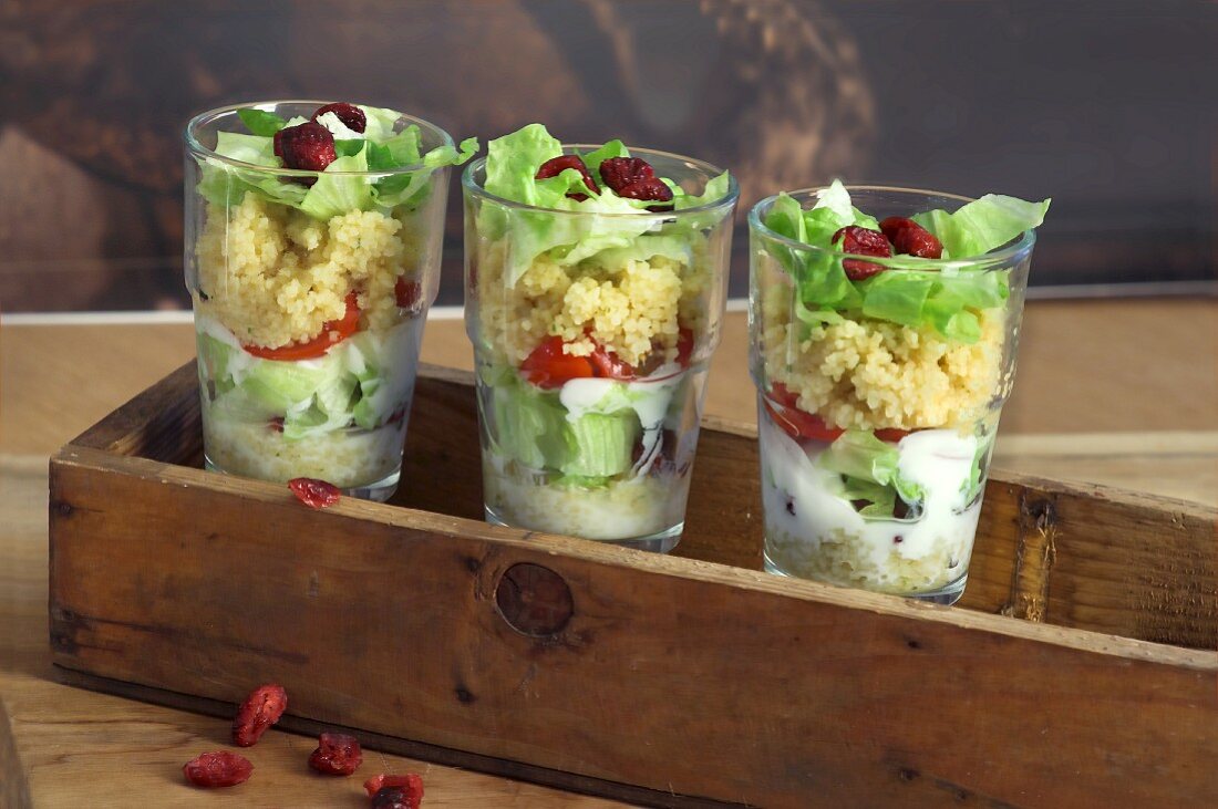 Couscous salad with tomatoes, iceberg lettuce and cranberries in glasses