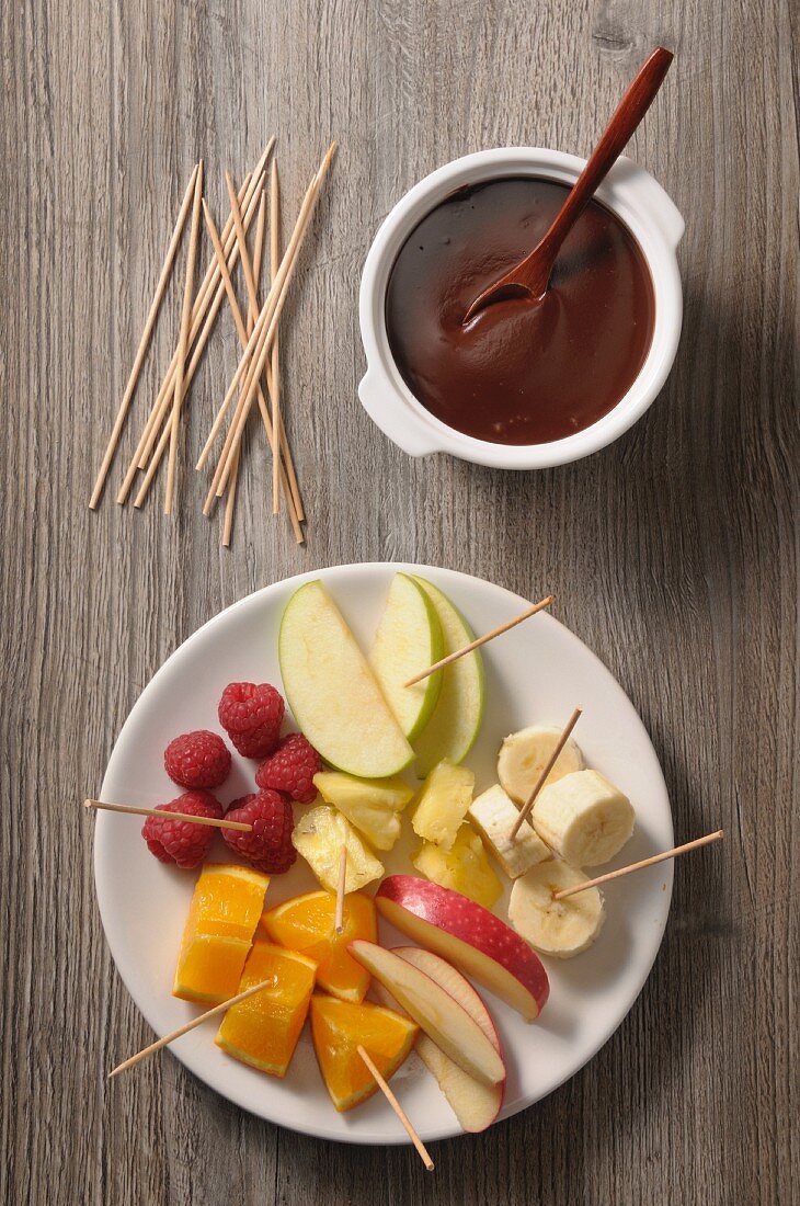 Chocolate fondue with various fruit skewers