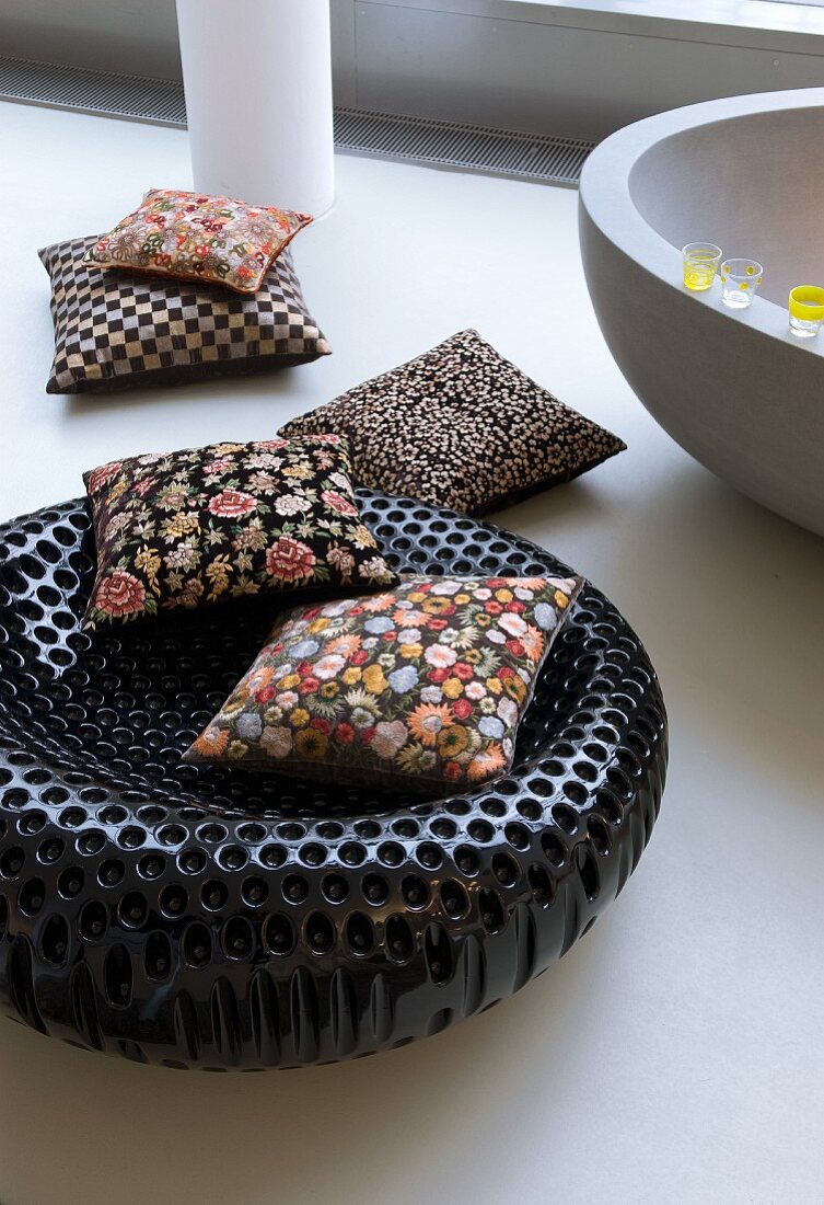 Floral cushions on black designer stool