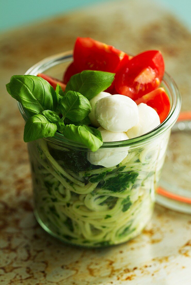 Lunch in a glass jar: spaghetti with spinach, mozzarella and basil