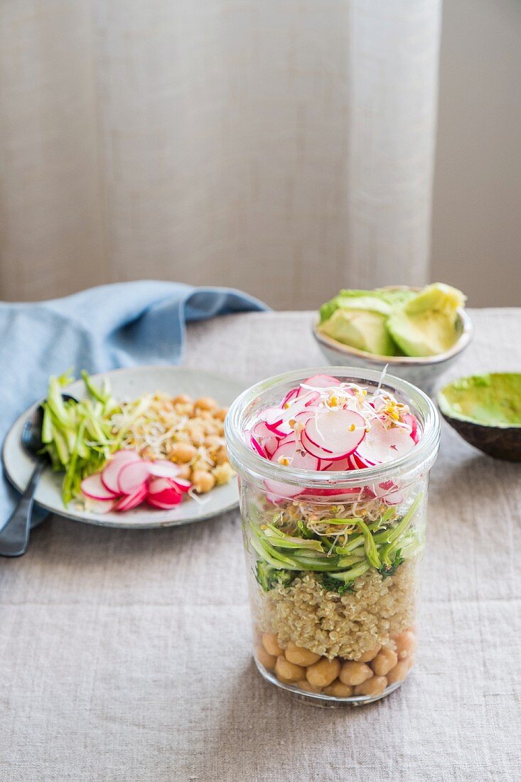 Layered salad with quinoa, chickpeas, asparagus, radishes and sprouts