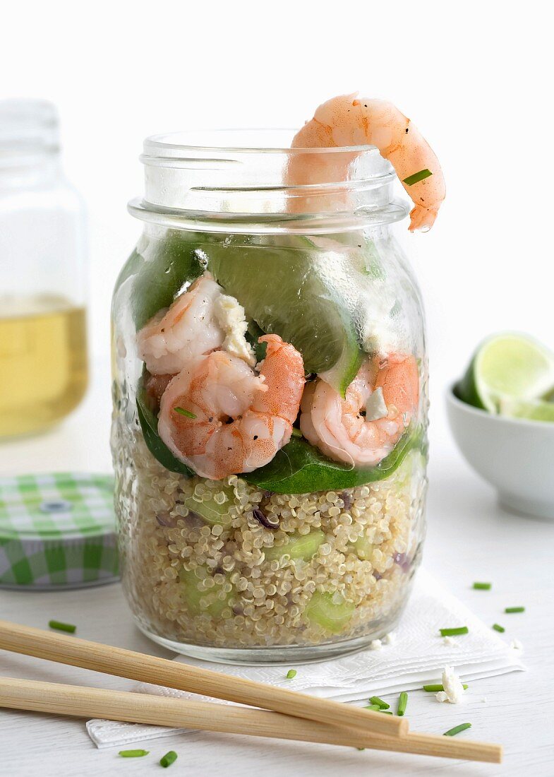 Giant prawns and quinoa in a glass with lime and baby spinach