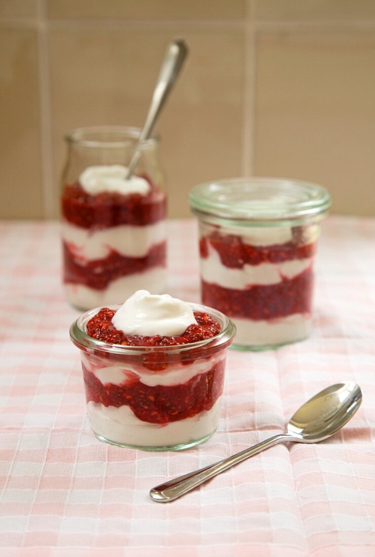 Vegan yoghurt dessert with raspberries layered in glasses