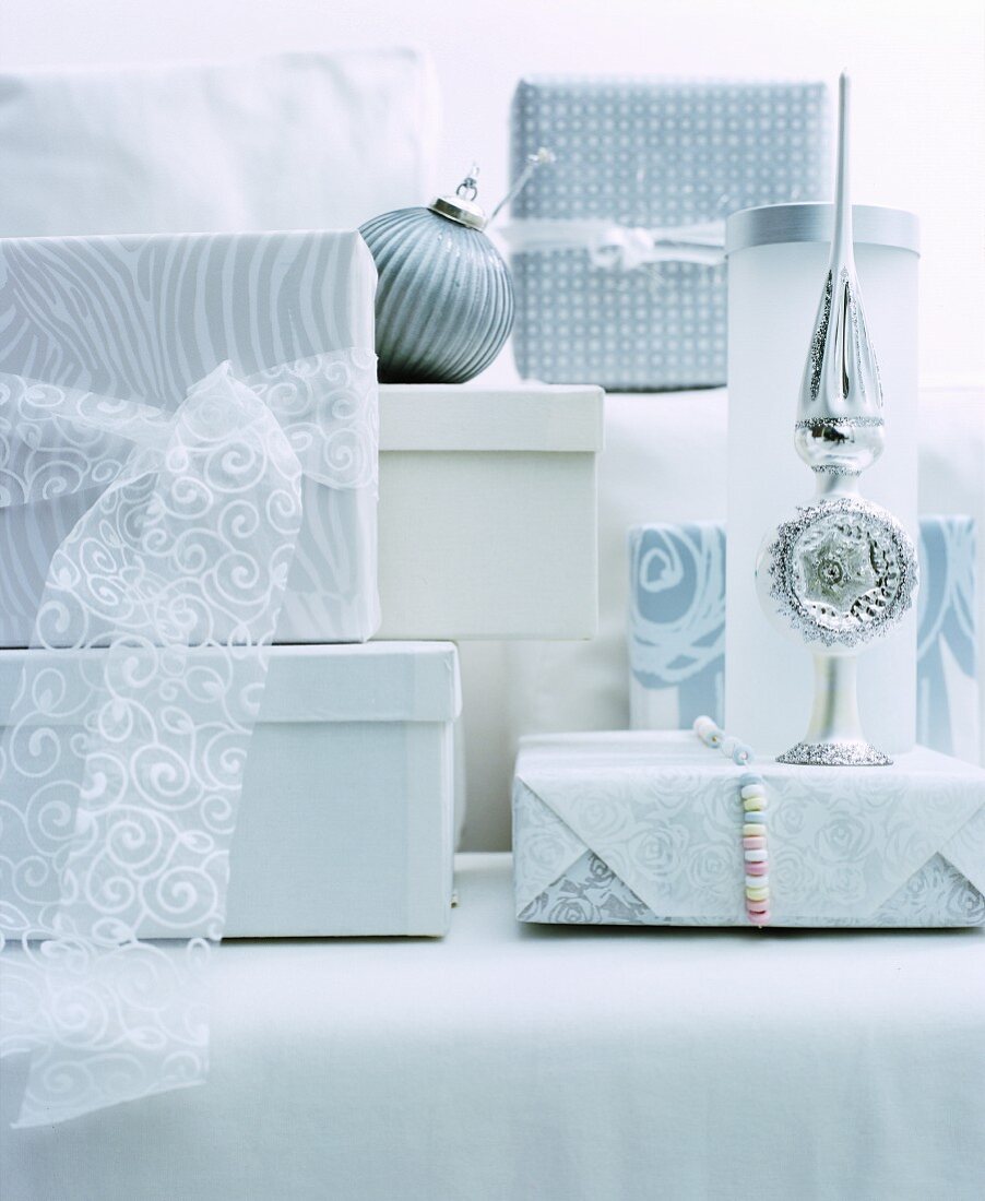 Wrapped gifts and Christmas-tree decorations in white and silver