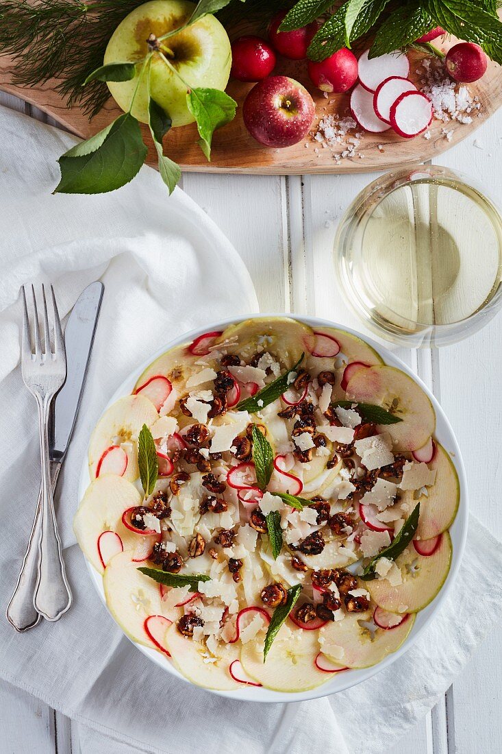 An apple and radish salad with herbs, hazelnuts and mint