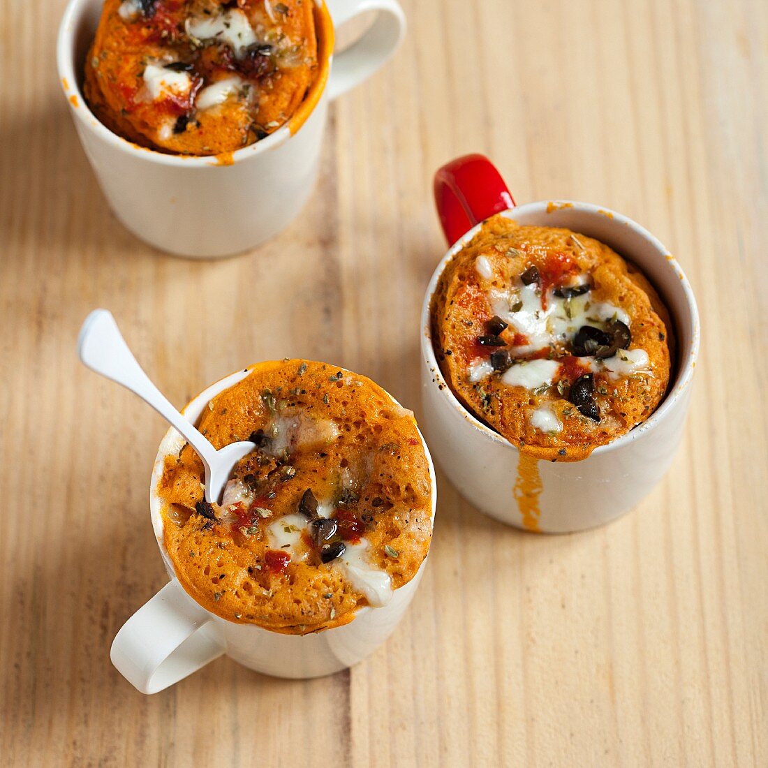 Savoury pizza mug cakes with olives, tomato and cheese