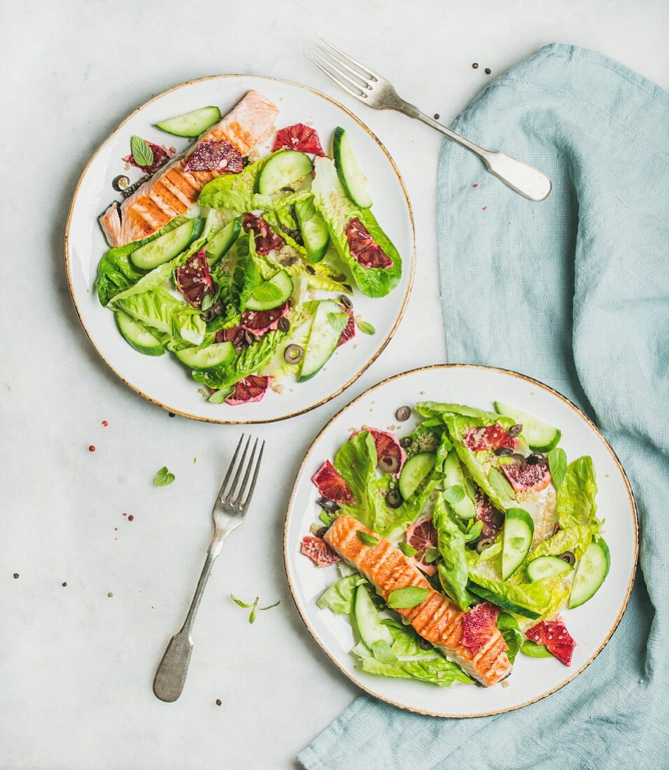Healthy energy boosting spring salad with grilled salmon, blood orange, olives and quinoa