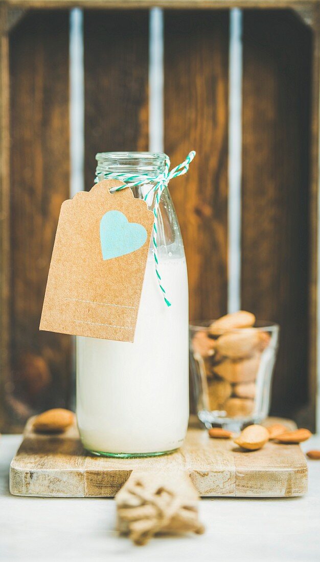 Fresh vegan dairy-free almond milk in glass bottle with craft paper label