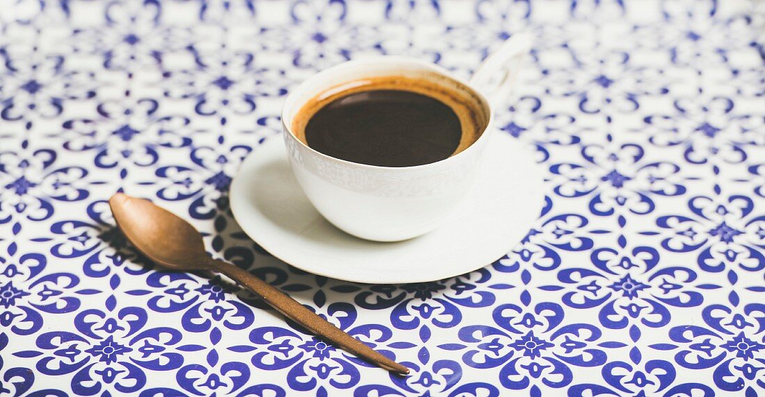 Eine Tasse schwarzer Kaffee auf marokkanischem Fliesenboden