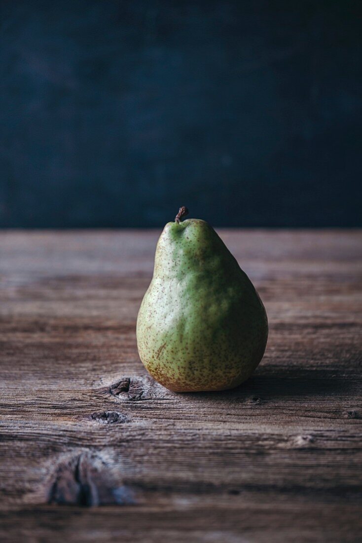 Single pear on a rustic wooden table