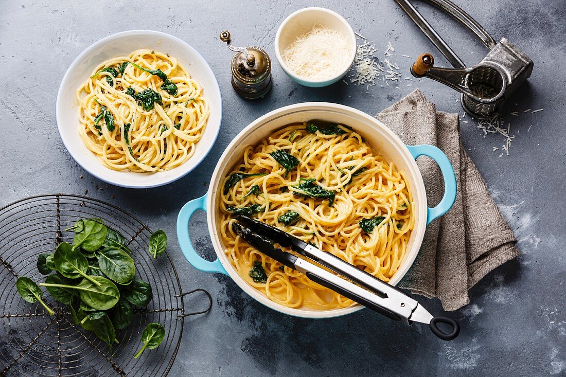 Spaghetti with Spinach and cream sauce in pan on gray concrete background