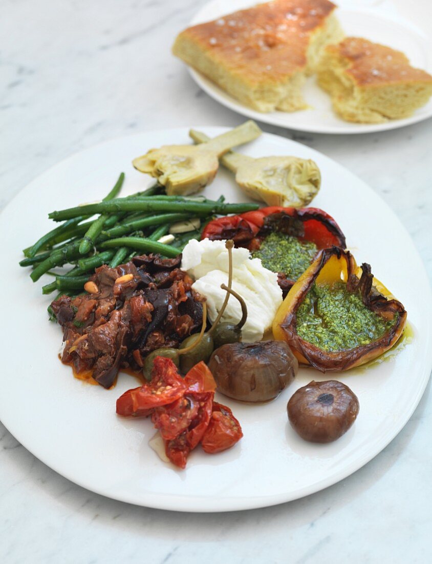 An antipasti platter with vegetables and mozzarella