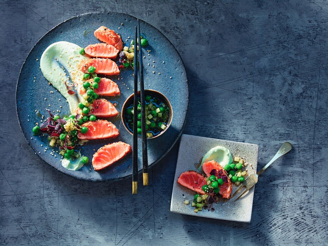 Salmon tataki coated in sesame seeds on wasabi and lime crème fraîche and pea and cucumber salad