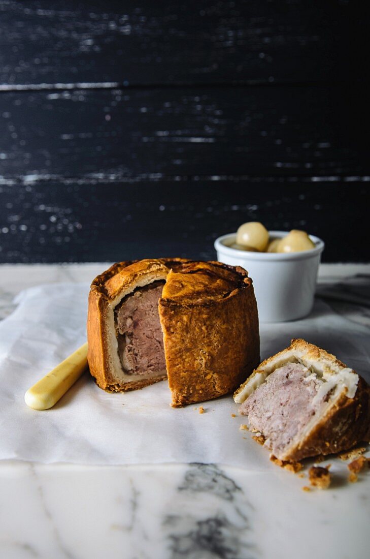 Pork Pie (Pastete mit Schweinefleisch), angeschnitten auf Marmoruntergrund