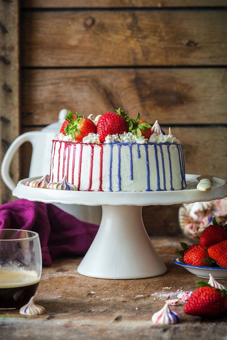 Buttercremetorte mit Erdbeeren und bunten Glasurstreifen