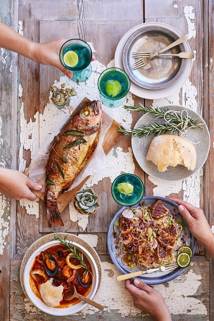 Ganzer gebackener Fisch, Meeresfrüchte-Bouillabaisse, Nudelsalat mit Thunfisch und Fladenbrot