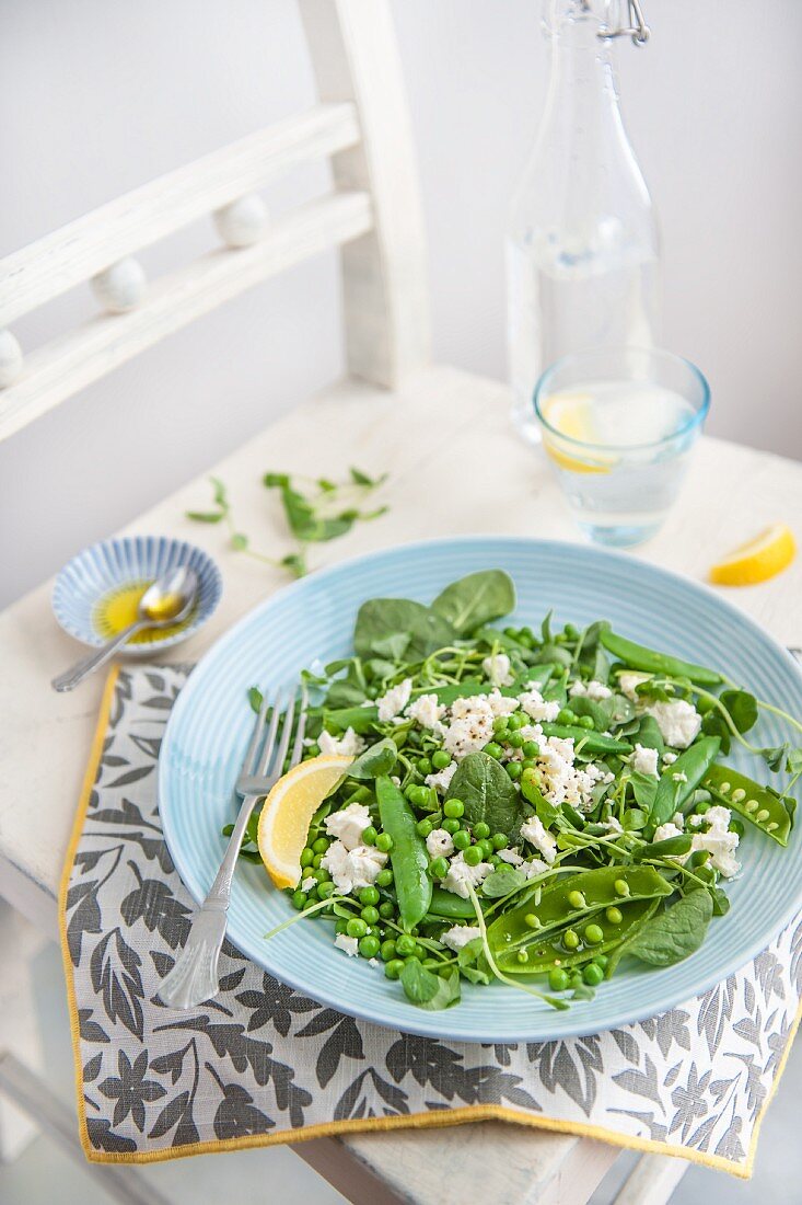 Salat mit Erbsen, Erbsensprossen, Bohnen, Feta, Olivenöl und Zitrone