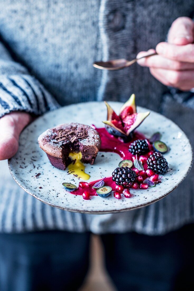 Chocolate cake with a liquid egg liqueur centre, raspberry sauce and autumn fruits