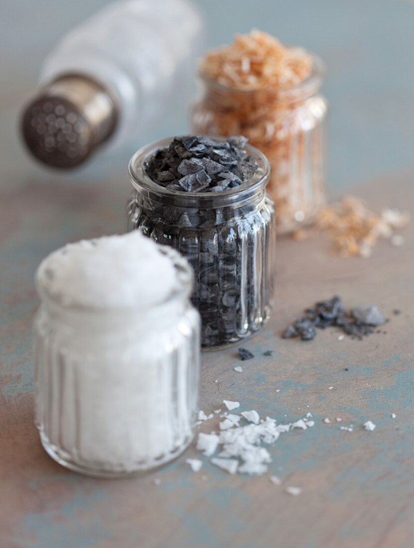 Schwarzes Salz, Paprikasalz und Meersalzflocken in Gläsern