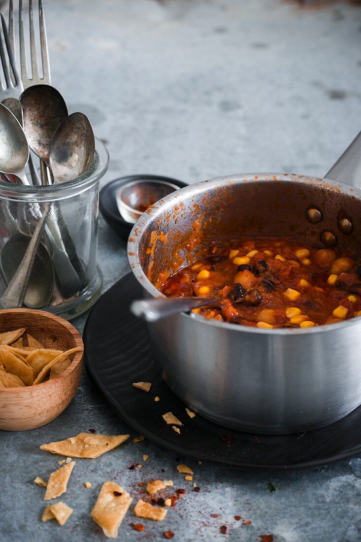 Veganes Chili mit Bohnen, Mais und Kichererbsen im Kochtopf (Mexiko)