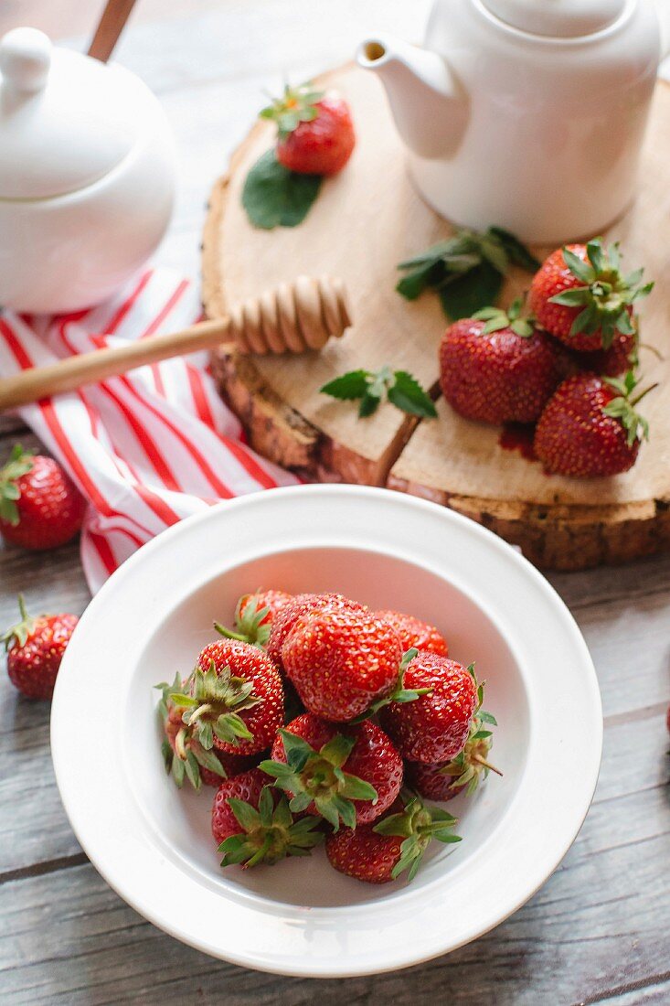 Frische Erdbeeren, Honig und Teekanne