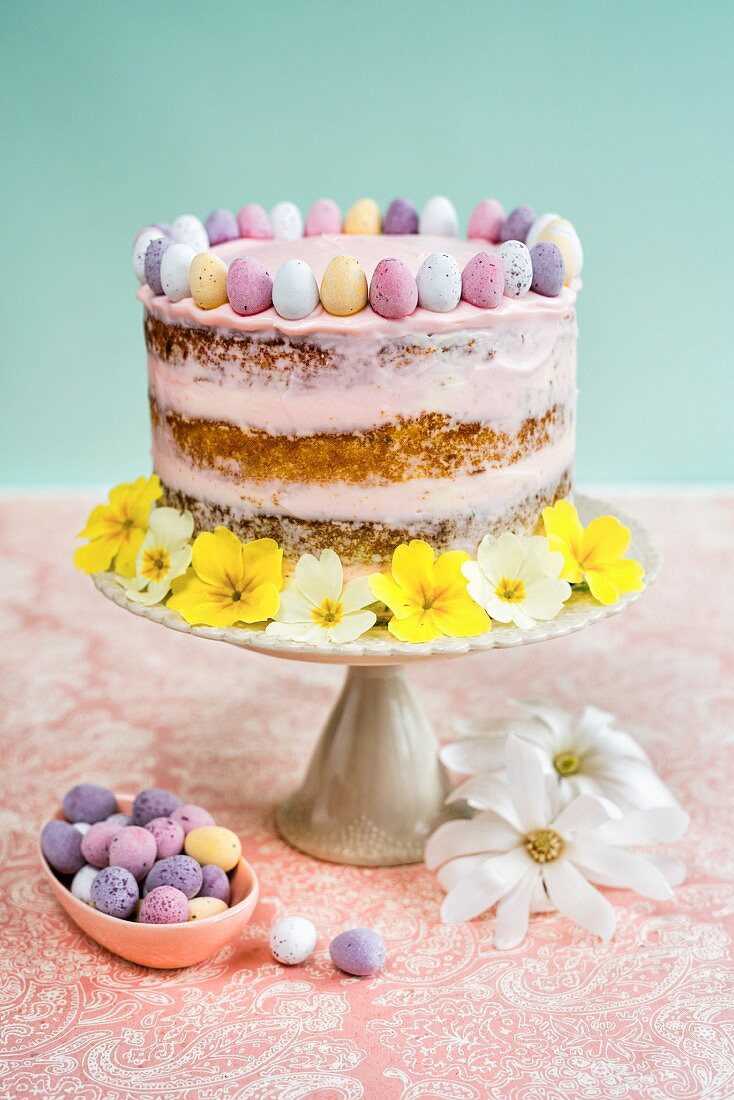 An Easter cake decorated with mini chocolate eggs and flowers