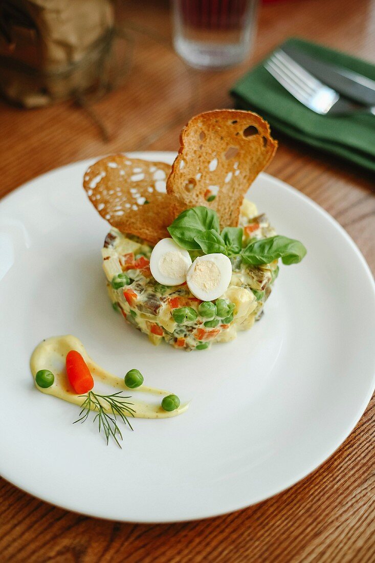 A vegetable tart garnished with quail's egg and crunchy bread chips