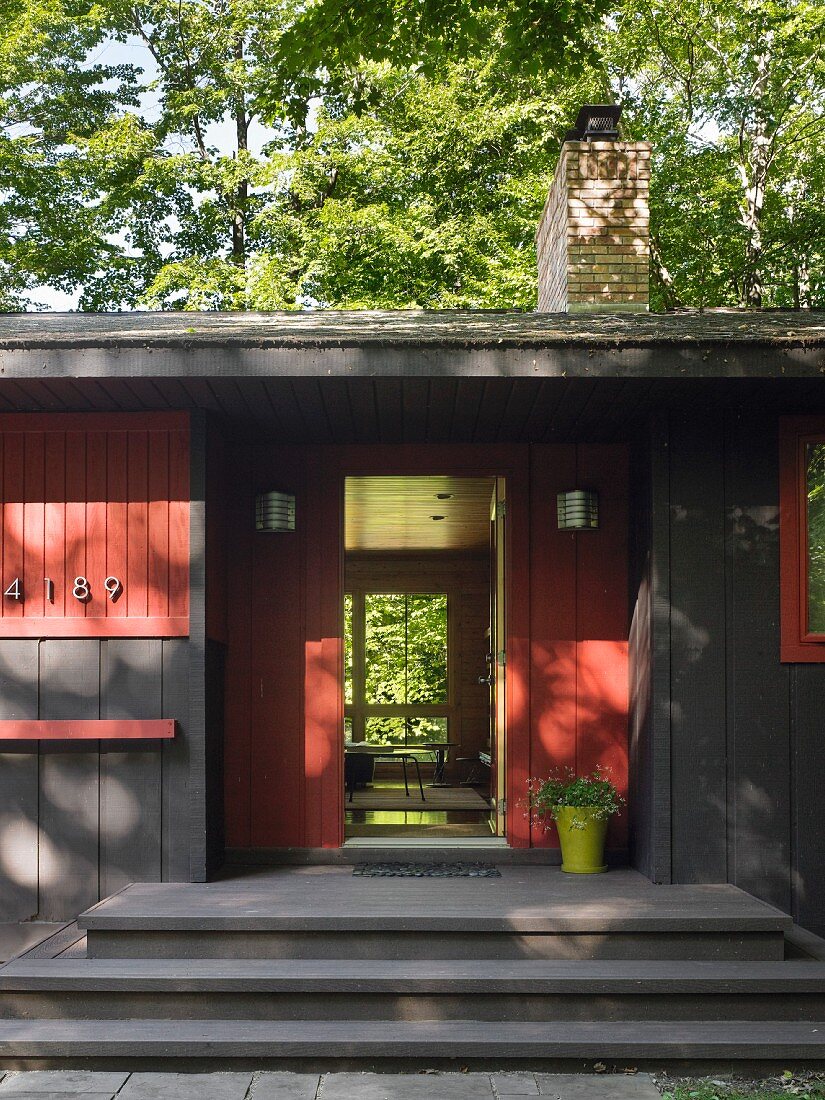 Steps leading to open front door of renovated wooden house