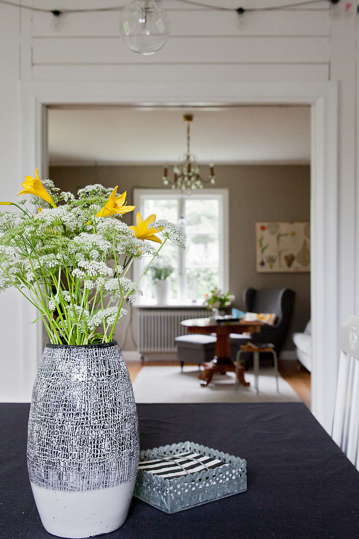 Garden flowers on table with view into living room